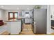 Kitchen with stainless steel refrigerator and range, white cabinets, granite countertops, and hardwood flooring at 31551 Black Widow Dr, Conifer, CO 80433