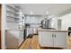 Bright kitchen featuring white cabinets, granite countertops, stainless steel appliances, and hardwood flooring at 31551 Black Widow Dr, Conifer, CO 80433