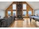 Spacious living room with wood-paneled walls, stone fireplace, and ample natural light at 31551 Black Widow Dr, Conifer, CO 80433