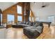 Open-concept living space with vaulted ceilings, a stone fireplace, and abundant natural light, perfect for entertaining at 31551 Black Widow Dr, Conifer, CO 80433