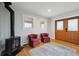 Comfortable living area with a cozy wood-burning stove, two plush armchairs, and a walk out to the deck at 31551 Black Widow Dr, Conifer, CO 80433