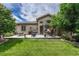 Spacious backyard with a concrete patio featuring outdoor seating and a grill, perfect for entertaining at 2868 Breezy Ln, Castle Rock, CO 80109