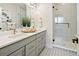 A sleek bathroom offers double sinks, modern fixtures, and a glass enclosed shower at 888 S Valentia St # 102, Denver, CO 80247