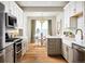 Bright, modern kitchen with stainless steel appliances and adjacent dining area bathed in natural light at 888 S Valentia St # 102, Denver, CO 80247