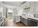 Modern kitchen with stainless steel appliances, island, and adjacent dining area with ample natural light at 888 S Valentia St # 102, Denver, CO 80247