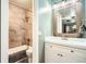 Bathroom featuring a new vanity with a rustic wooden mirror, complementing the tiled shower and tub at 9483 W 89Th Cir, Broomfield, CO 80021