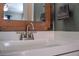 Close-up on the bathroom vanity showcasing its modern faucet and a rustic wooden framed mirror with a towel at 9483 W 89Th Cir, Broomfield, CO 80021