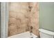 Close-up of tub and shower area showcasing neutral-toned tiles, updated fixtures, and a gray shower curtain at 9483 W 89Th Cir, Broomfield, CO 80021