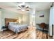Cozy bedroom with ceiling fan, and adjacent bathroom, showcasing wood flooring and a unique headboard at 9483 W 89Th Cir, Broomfield, CO 80021