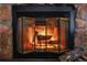 Close up of a beautiful stone fireplace with glass doors and a roaring fire at 9483 W 89Th Cir, Broomfield, CO 80021