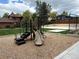 A community playground featuring wood chip ground cover with slide and climbing features surrounded by homes at 9483 W 89Th Cir, Broomfield, CO 80021