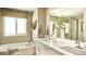 Bright bathroom featuring dual sinks, a soaking tub, and a large window with natural light at 3341 N Buchanan Way, Aurora, CO 80019