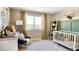 Cozy Bedroom features a crib, changing table, rocking chair, and ample natural light at 3341 N Buchanan Way, Aurora, CO 80019