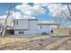 The backyard has mature trees, a wooden fence, and a view of the home's exterior at 19003 E Oxford Dr, Aurora, CO 80013