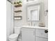 Well-organized bathroom featuring toilet, shelves, stylish mirror, and neutral gray vanity with storage at 19003 E Oxford Dr, Aurora, CO 80013