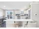 The modern kitchen is complete with white cabinets, stainless appliances and views to the breakfast bar at 19003 E Oxford Dr, Aurora, CO 80013