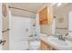 Cozy bathroom featuring a shower-tub combination, wood vanity, and an above-the-toilet cabinet at 19463 E Hollow Creek Dr, Parker, CO 80134