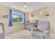 A Bedroom with crib and comfy recliner, bathed in natural light from a window at 19463 E Hollow Creek Dr, Parker, CO 80134