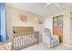 A cozy Bedroom with crib, glider chair, and closet, decorated with charming wall art at 19463 E Hollow Creek Dr, Parker, CO 80134