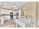 Bright kitchen featuring white cabinets, stainless steel appliances, and a dining area at 19463 E Hollow Creek Dr, Parker, CO 80134
