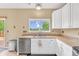 Bright kitchen featuring white cabinets, stainless steel appliances, and views of backyard at 19463 E Hollow Creek Dr, Parker, CO 80134