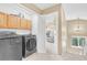 Laundry room featuring a washer, dryer, and overhead cabinets with a view into the hall at 19463 E Hollow Creek Dr, Parker, CO 80134