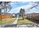 Grassy backyard with wood fence, a small outbuilding, and sidewalk at 2146 Federal Blvd, Denver, CO 80211