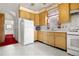 This is an image of a kitchen featuring wooden cabinets and white appliances at 2146 Federal Blvd, Denver, CO 80211