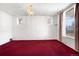 Sunlit room featuring white walls, bright red carpeting and a decorative chandelier at 2146 Federal Blvd, Denver, CO 80211