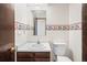 Compact bathroom featuring a vanity, toilet, and patterned wallpaper at 4653 Kirkwood St, Boulder, CO 80301