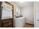 Laundry room featuring a washer and dryer, patterned wallpaper, and frilled curtains at 4653 Kirkwood St, Boulder, CO 80301