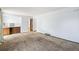 Spacious living area with white walls and carpet, open to a kitchenette area at 4653 Kirkwood St, Boulder, CO 80301