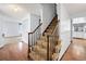 Carpeted stairs with wooden banister, wood-look flooring, and patterned wallpaper at 4653 Kirkwood St, Boulder, CO 80301