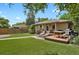 Spacious backyard area with a deck, patio, outdoor seating, and lush artificial grass at 1600 Olive St, Denver, CO 80220
