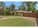 Large, well-maintained backyard with artificial grass, a walkway, and mature trees at 1600 Olive St, Denver, CO 80220