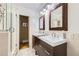 Modern bathroom featuring double sinks, walk-in shower with glass door, and tiled floor at 1600 Olive St, Denver, CO 80220