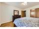 Bright bedroom with a full-sized bed, dresser with mirror, and sliding closet doors at 1600 Olive St, Denver, CO 80220