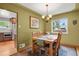Inviting dining room with a wooden table, four chairs, and view to the kitchen and backyard at 1600 Olive St, Denver, CO 80220