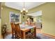 Open dining room with a wooden table, seating, and a seamless transition to the adjacent living space at 1600 Olive St, Denver, CO 80220