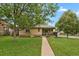 Quaint single-story home with a welcoming front porch and lush green lawn leading to the entrance at 1600 Olive St, Denver, CO 80220