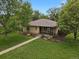 Charming single-story home featuring mature trees and beautifully landscaped front yard at 1600 Olive St, Denver, CO 80220