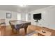 Spacious game room with pool table and mounted TV for entertainment at 1600 Olive St, Denver, CO 80220