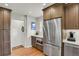 A kitchen with stainless steel refrigerator, brown cabinets, and granite countertops at 1600 Olive St, Denver, CO 80220