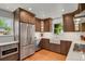 Modern kitchen featuring stainless steel appliances, dark wood cabinets, and a bright, farmhouse-style sink at 1600 Olive St, Denver, CO 80220