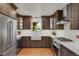Bright kitchen featuring stainless steel appliances, brown wood cabinets, a farmhouse sink, and herringbone tile backsplash at 1600 Olive St, Denver, CO 80220