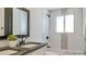 Elegant bathroom showcasing a double vanity, sleek fixtures, and tiled tub with a window allowing natural light to fill the space at 2510 Kenton, Aurora, CO 80010