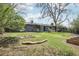Spacious backyard with green lawn, mature trees, and fire pit area at 3179 S University Blvd, Englewood, CO 80113