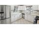 A bright kitchen features ample countertop space, white cabinetry, stainless appliances, and tile flooring at 3179 S University Blvd, Englewood, CO 80113