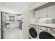 Open kitchen with laundry closet features stainless appliances, white cabinets, and ample counter space at 3179 S University Blvd, Englewood, CO 80113