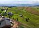 Picturesque view of a residence surrounded by lush, rolling hills and distant mountain scenery at 16535 W 79Th Dr, Arvada, CO 80007